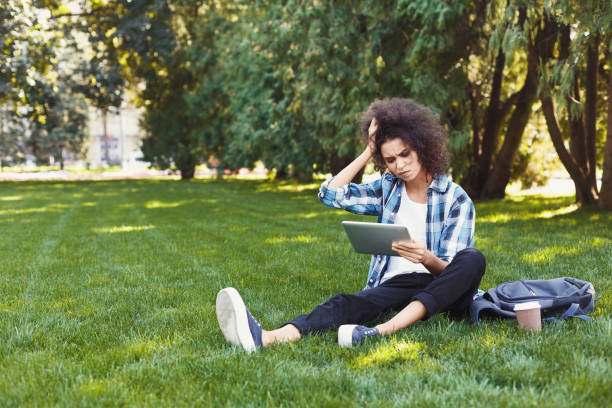 istock Young sad woman using smartphone in park 939589314