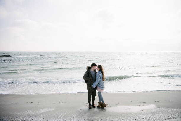 istock young couple hugging on winter seashore 939589892