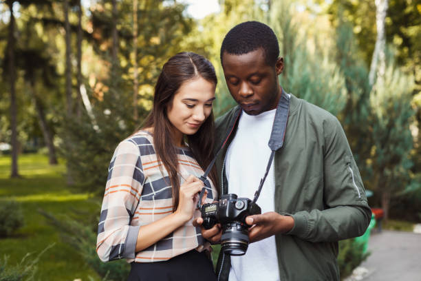istock Multiethnic couple watching pictures on camera 939590470