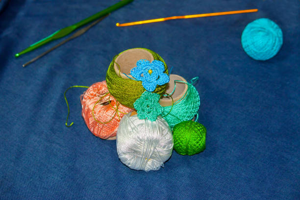 istock Threads for knitting on a blue background. Handmade concept. Crochet hooks and multi-colored yarn look bright. 939594072