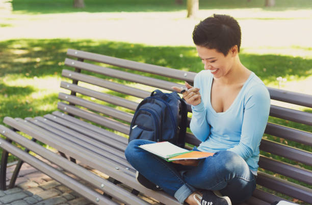 istock Shorthaired girl writing in notebook outdoors 939597924