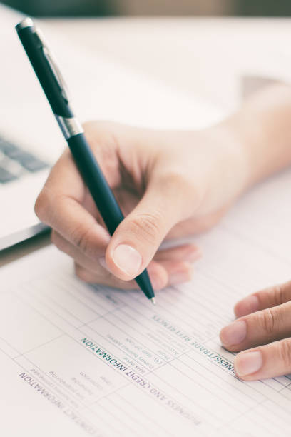 istock Closeup of Business Person Completing Form 939598314