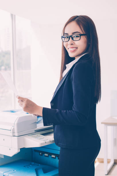 istock Smiling Business Woman Using Photocopier in Office 939598498