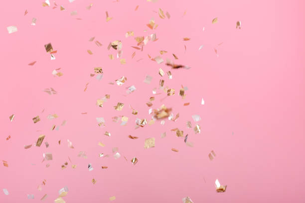 istock Golden confetti on pink background 939610546