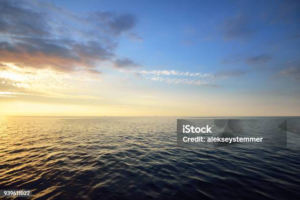 Sunset In A Cloudy Sky Over Open Baltic Sea With Veri Distant Ship Silhouettes Stock Photo - Download Image Now