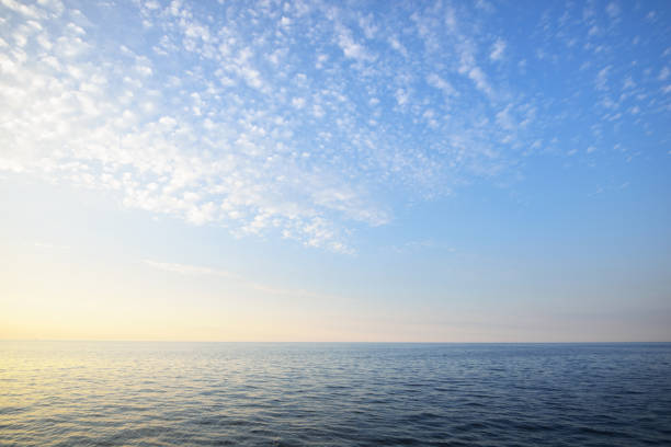 Sunset over an open baltic sea and gentle clouds above it