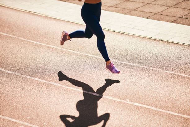 istock woman running on atlethic track. 939615820