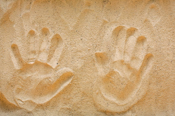 istock Handprints on yellow beach sand, top view 939616134