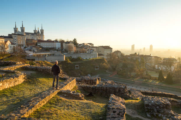 Lyon at dawn Man looking at the sunrise over Lyon from Theatre Gallo Romain, the ancient Roman theatre of Fourvier in Lyon, France. fourviere stock pictures, royalty-free photos & images