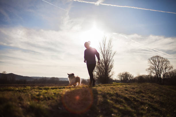 istock Senior woman running with dog 939632078