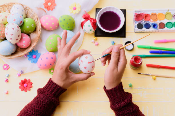 istock Happy easter! A woman hand painting Easter eggs. Happy family preparing for Easter. 939636990
