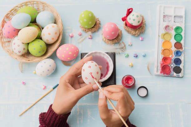 istock Happy easter! A woman hand painting Easter eggs. Happy family preparing for Easter. 939637006