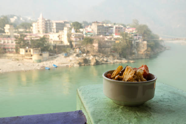 A dish of grilled and stewed vegetables on the background of the river Ganges. Rishikesh India., yoga city India, Gange River Ganga Ram Jhoola Jula