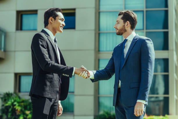 istock Two Smiling Adult Business Men Shaking Hands 939637912