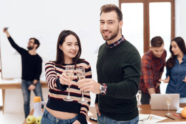 istock A young couple celebrates at a corporate celebration. 939638676