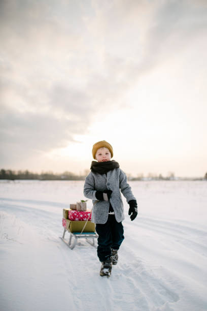 istock A Boy drags a sled with christmas presents in the sunset 939644030