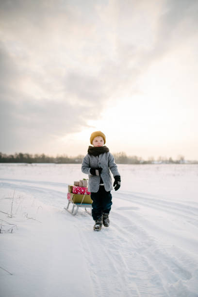 istock A Boy drags a sled with christmas presents in the sunset 939644036