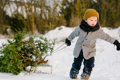 Authentic nordic family photoshoot with christmas presents and christmas tree.