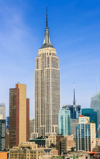 empire state building, new york city skyline avec les gratte-ciels de midtown manhattan et ciel bleu vif. - clear sky vacations vertical saturated color photos et images de collection
