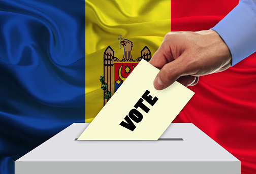 Man voting on elections in Moldova front of flag