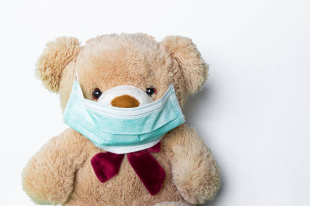istock Cute teddy bear with face mask on his mouth on white background 939676032