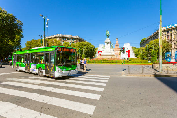 the crosswalk and bus are near metro station cairoli which is located on the piazzale cairoli and the bronze monument to giuseppe garibaldi on piazzale cairoli - travel passenger milan italy italy imagens e fotografias de stock