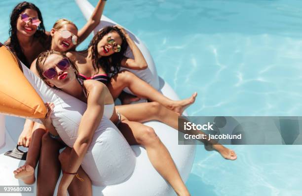 Women Floating Together On A Big Inflatable Toy In Pool Stock Photo - Download Image Now