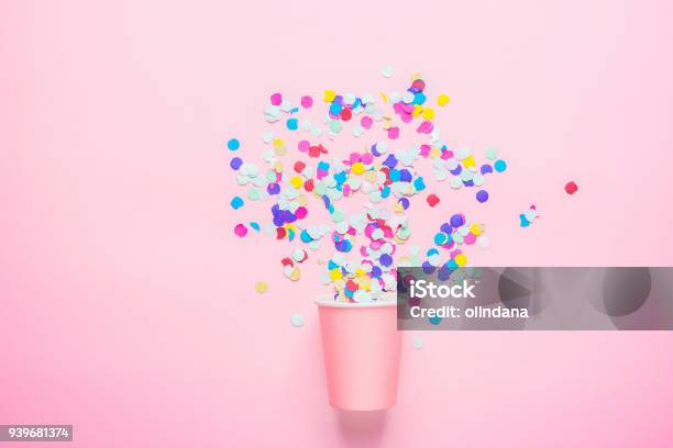 Foto de Beber O Copo De Papel Com Confetes Coloridos Espalhados Em Fundo Fúcsia Composição Plana Leiga Festa De Aniversário Festa Crianças Atmosfera Alegre Divertida Modelo De Cartaz De Cartão Espaço De Cópia e mais fotos de stock de Confete