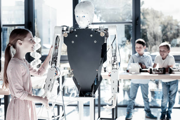 istock Friendly girl shaking hands with human like robot 939692206