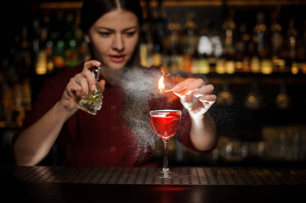istock Female bartender spraying on the fire match above the cocktail 939694380