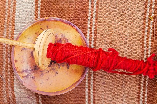 Spindle with alpaca wool dyed red seen from above