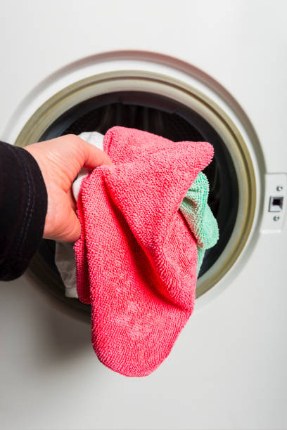 istock woman louding laundry into washing machine 939695752