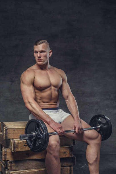 fisiculturista em uma calcinha branca situa-se na caixa de madeira. - abdominal muscle muscular build barbell bicep - fotografias e filmes do acervo