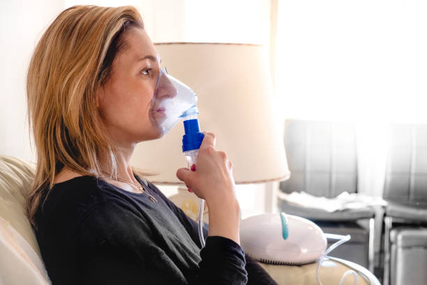 nebulizador aerossol mulher inalador máquina medicamento em casa - nebulizer - fotografias e filmes do acervo