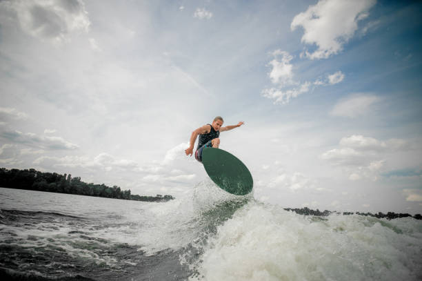 istock Young and active man wakesurfing on the board 939720698