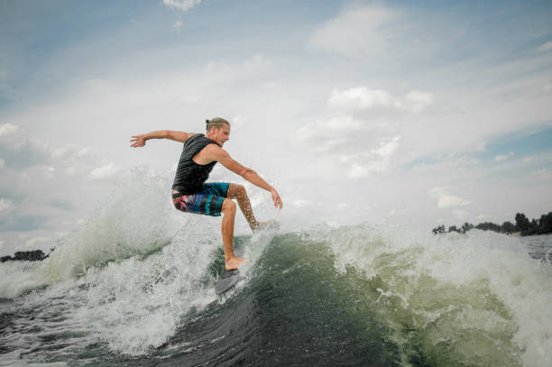 istock Active wakesurf rider jumping on the waves of the river 939721364