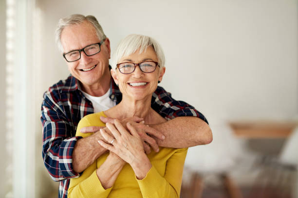 I know he's always got my back Cropped portrait of a senior man affectionately embracing his wife at home eyeglasses stock pictures, royalty-free photos & images