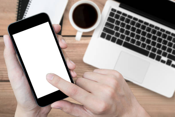 istock Man using smartphone over the office desk, top view. 939731488