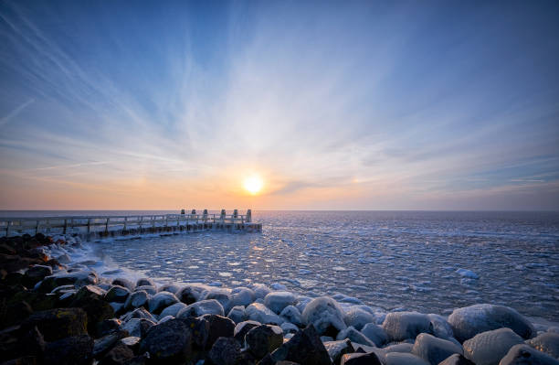 istock Frozen lake with an icy jetty during sunrise 939732298
