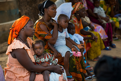 Bissau, Republic of Guinea-Bissau - January 29, 2018: Portrait of a young mother and her baby daughter during a community meeting, at the Bissaque neighborhood in the city of Bissau, Guinea Bissau.