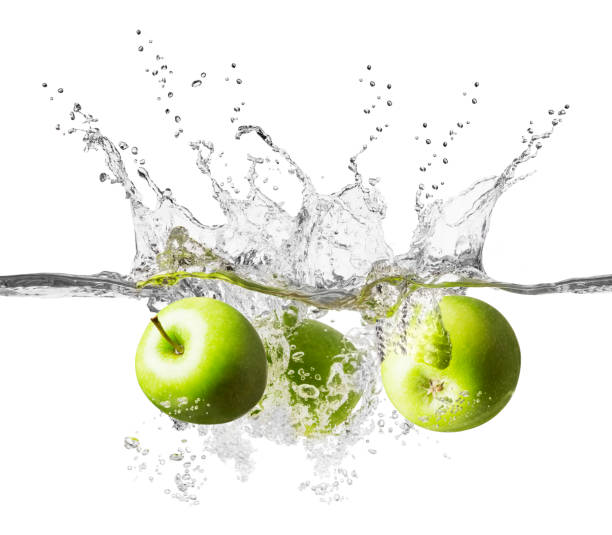 istock Three fresh green apples splashing into crystal clear water 939741920