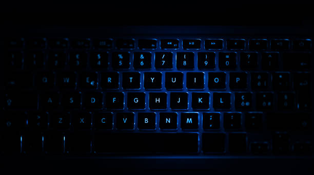 Closeup of laptop keyboard illumination, blue backlit keyboard