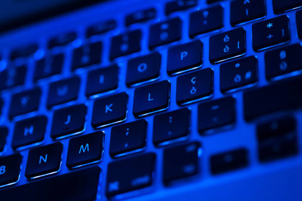 istock Closeup of laptop keyboard illumination, blue backlit keyboard 939745594