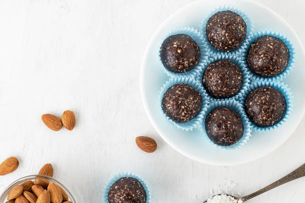 Chocolate energy bites with nuts, cocoa powder, dates and coconut flakes. stock photo