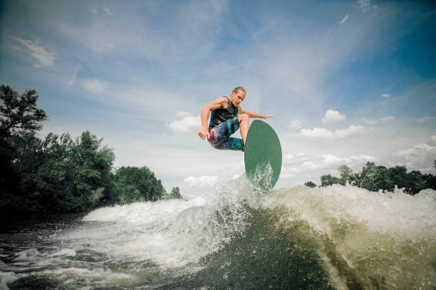 istock wakeboarder rides up the wake 939754866