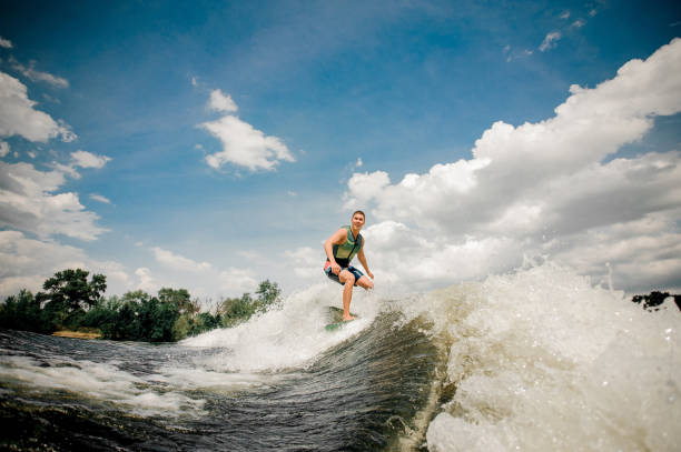 istock surfer riding wakeboard on high wave of motorboat 939757864