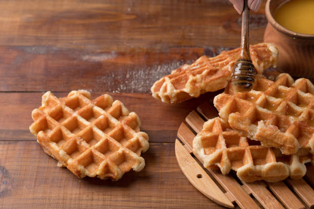 istock Honey pouring on a fresh waffles. Breakfast with waffles 939758418