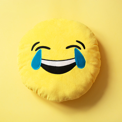 Emoji as soft yellow pillow. Close up. Pattern