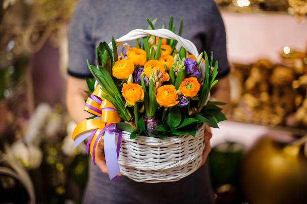 mujer sosteniendo una cesta de mimbre con flores - wicker basket store gift shop fotografías e imágenes de stock