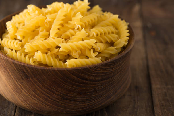 istock Raw pasta in wood plate on wood background 939778822